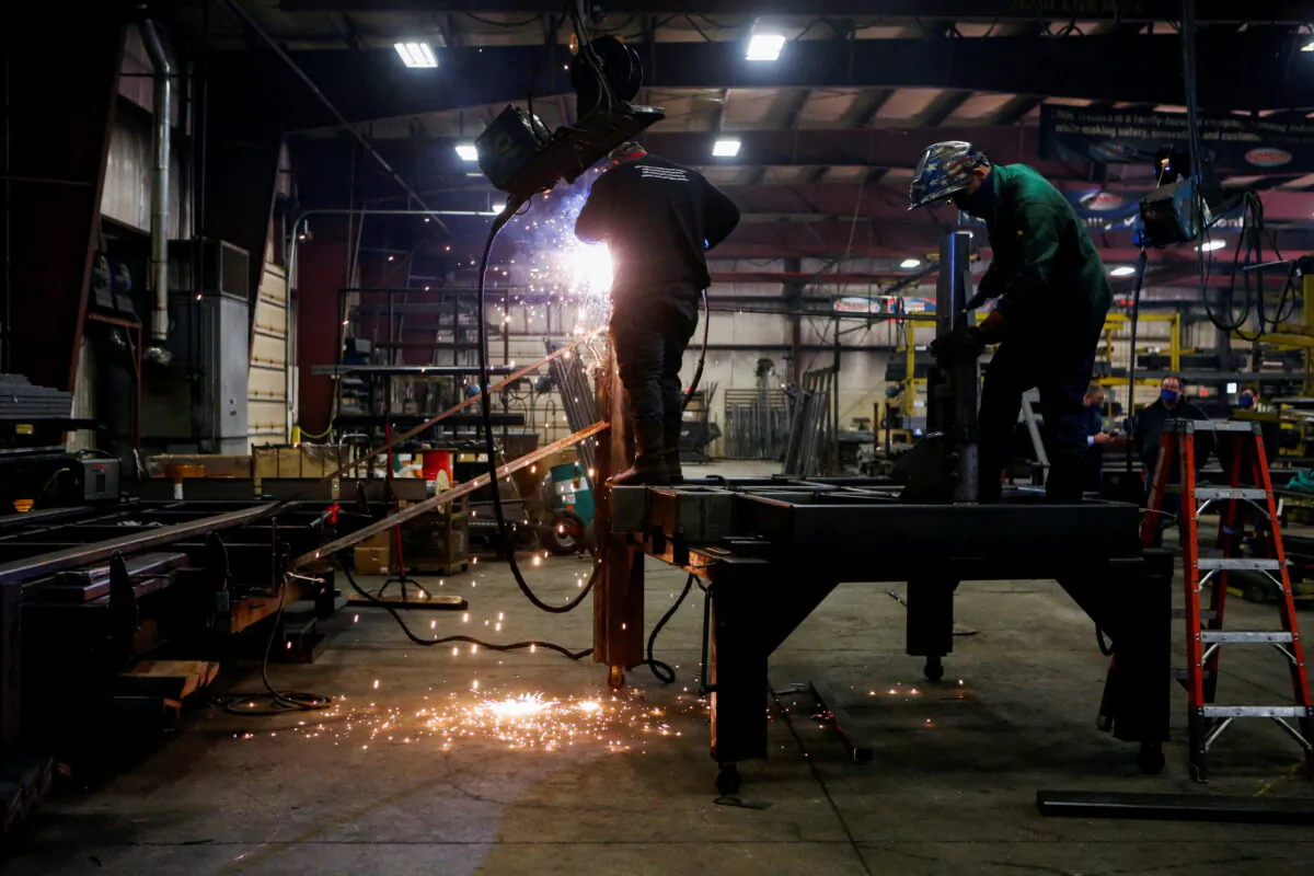 Matt Dillion and Chad Damron weld an upper deck assembly at Look Trailers cargo trailer manufacturing facility in Middlebury, Ind., on April 1, 2021. (Eileen T. Meslar/Reuters)