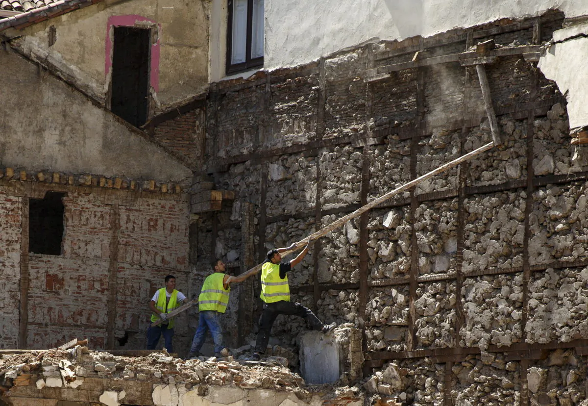 Construction workers try to throw down a beam in downtown Madrid, Spain, on July 23, 2015. (Andrea Comas/Reuters)