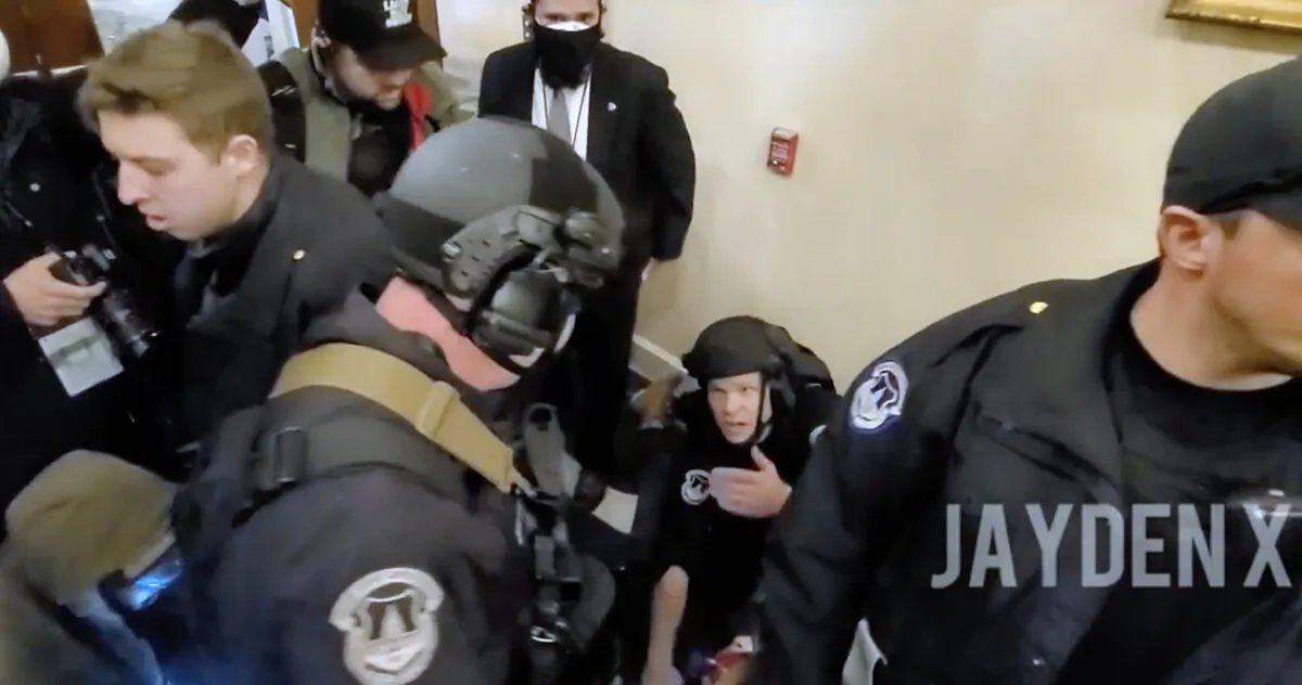 U.S. Capitol Police Officer Steven Robbs kneels over Ashli Babbitt just after she was shot by Lt. Michael Byrd in the hallway outside the Speaker's Lobby on January 6, 2021. (JaydenX/Screenshot via The Epoch Times)