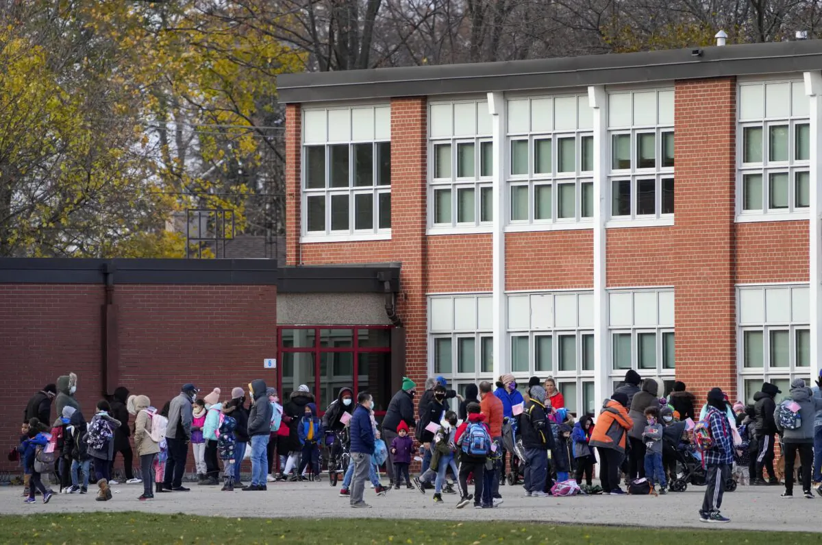 Parents pick up their children as they are dismissed from a school in Mississauga, Ont., on Nov. 22, 2021. (The Canadian Press/Nathan Denette)
