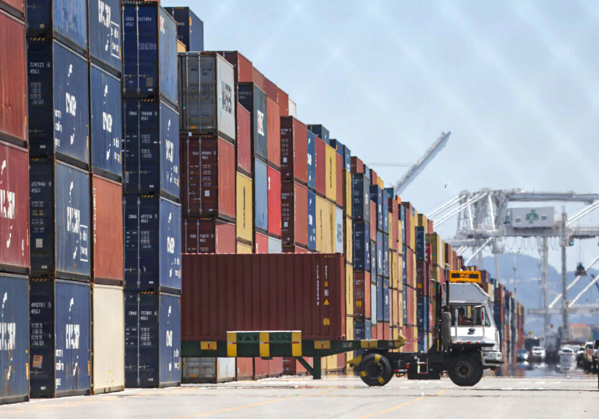 A truck drives by stacks of shipping containers at the Port of Oakland in Oakland, California on May 20, 2022. (Justin Sullivan/Getty Images)