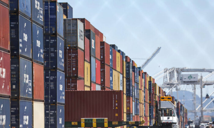A truck drives by stacks of shipping containers at the Port of Oakland in Oakland, California on May 20, 2022. (Justin Sullivan/Getty Images)
