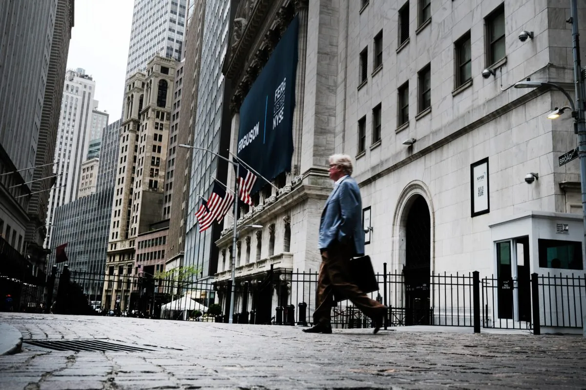 People walk by the New York Stock Exchange (NYSE) on May 12, 2022. Prices of clothing, food, gas, and cars are just a few of the items that are hitting Americans' pocketbooks despite historically low unemployment. (Spencer Platt/Getty Images)