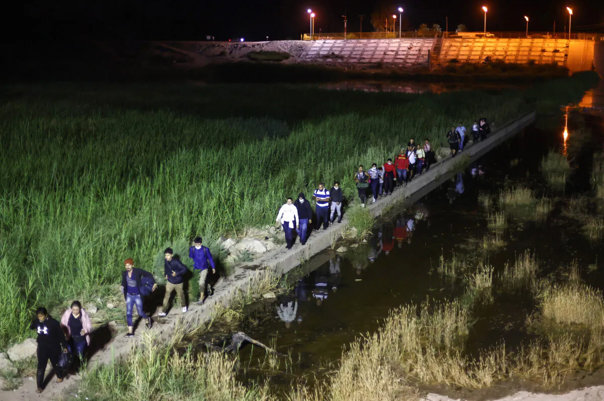 Immigrants walk from Mexico into the United States on their way to await processing by the U.S. Border Patrol in Yuma, Ariz., on May 23, 2022. (Mario Tama/Getty Images)
