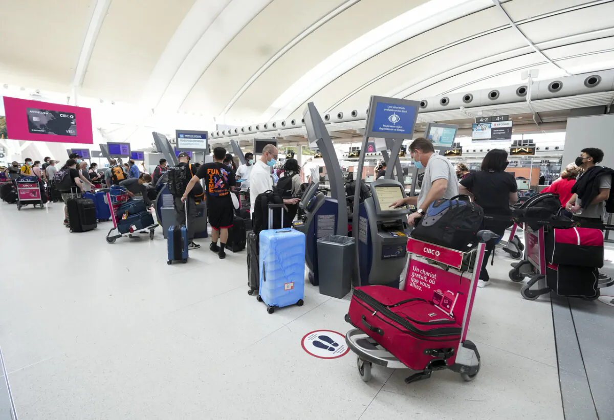 People wait in line to check in at Pearson International Airport in Toronto on May 12, 2022. (Nathan Denette/The Canadian Press)