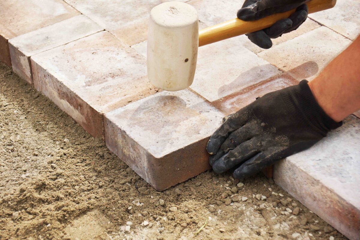 Installing paver bricks on patio. (Sylvie Bouchard/Shutterstock) 