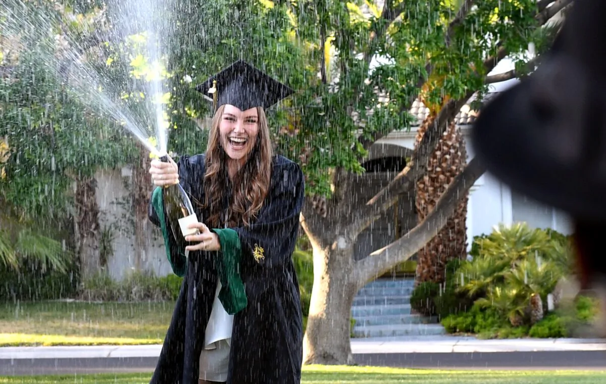 College of William & Mary graduate Julia Carlson is spraying champagne in a park across from her home in Henderson, Nevada on May 15, 2020. (Ethan Miller/Getty Images)