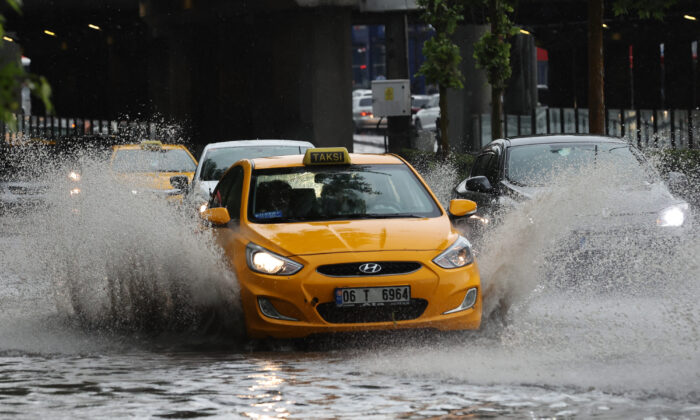A taxi drives through a street flooded by heavy rain in Ankara, Turkey, on June 11, 2022. (Adem Altan/AFP via Getty Images)