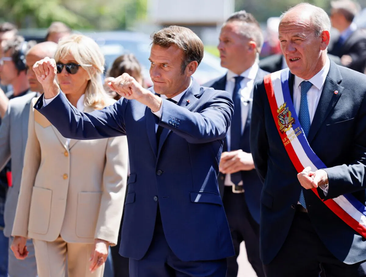 French President Emmanuel Macron gestures as he walks with Touquet's mayor Daniel Fasquelle during the first round of French parliamentary elections, at a polling station in Le Touquet, France, on June 12, 2022. (Ludovic Marin/Pool via Reuters)