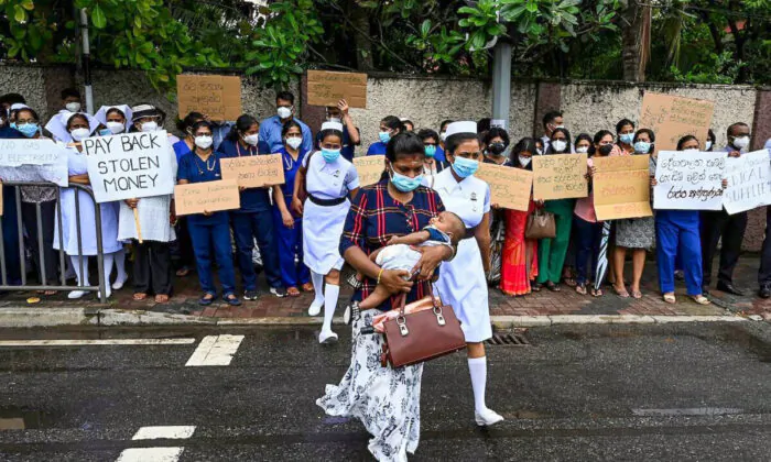 Doctors and nurses of the Lady Ridgeway Children's hospital hold placards during a silent demonstration against shortages of medicines in Colombo, Sri Lanka, on April 19, 2022. (Ishara S. Kodikara/AFP via Getty Images)