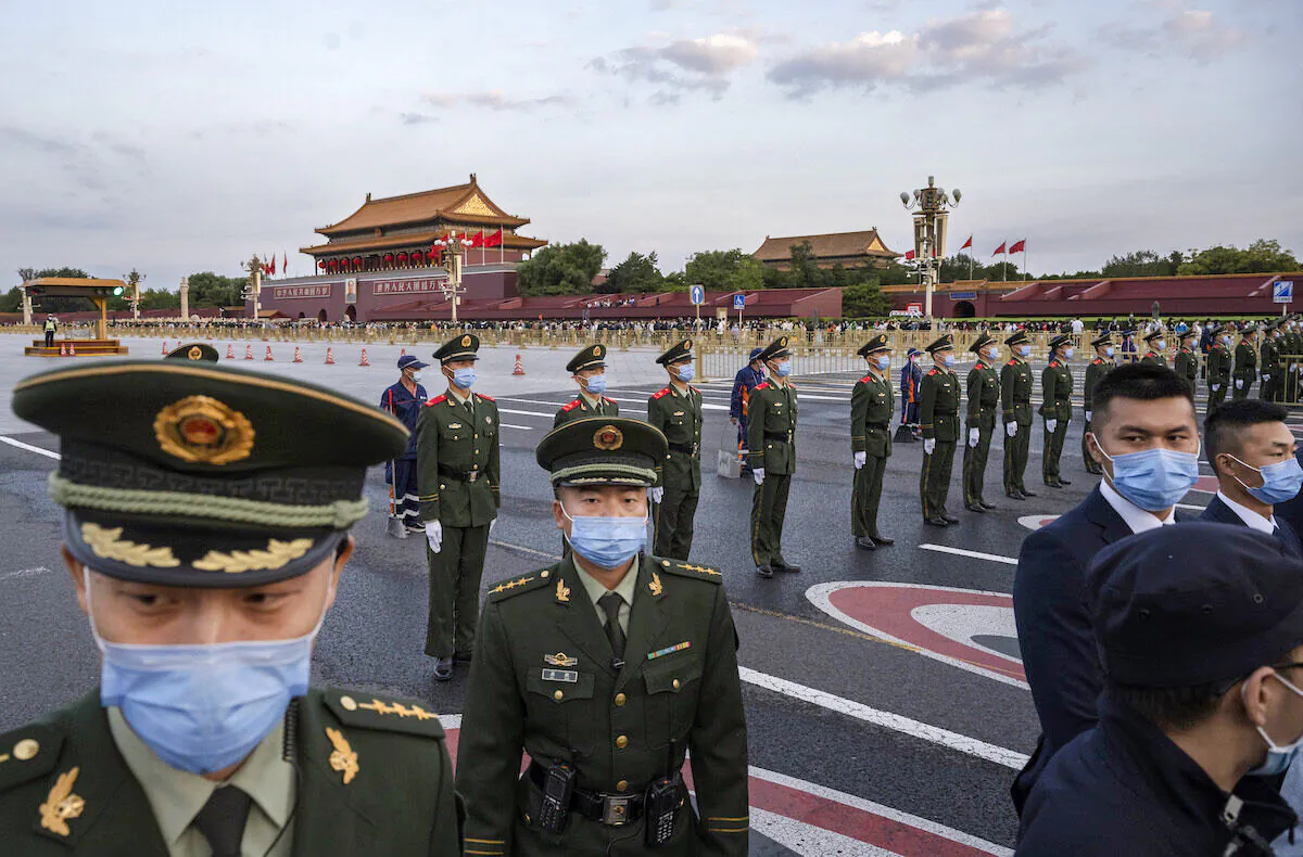 Police officers and security perform crowd control after an official flag raising ceremony to mark National Day next to Tiananmen Square and the Forbidden City on October 1, 2021 in Beijing, China. (Kevin Frayer/Getty Images)