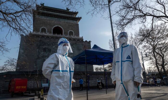 Health workers wear protective suits in Beijing on March 21, 2022. (Kevin Frayer/Getty Images)