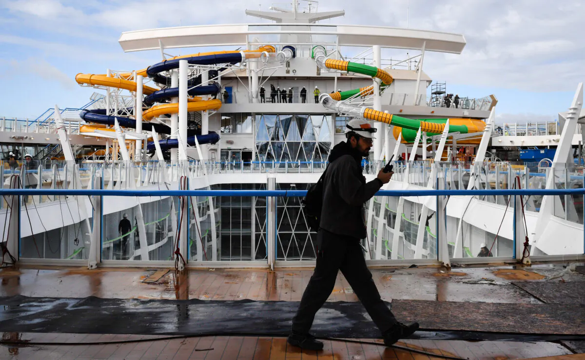 A worker walks across the upper deck of U.S. shipowner Royal Caribbean's new Oasis-class cruise ship, Symphony of the Seas, in the port of Saint-Nazaire, western France, on Feb. 13, 2018.
(Fred Tanneau/AFP via Getty Images)