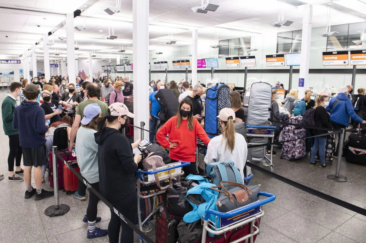 Travellers wait in line at a check-in desk at Trudeau Airport in Montreal on April 20, 2022. (The Canadian Press/Graham Hughes)
