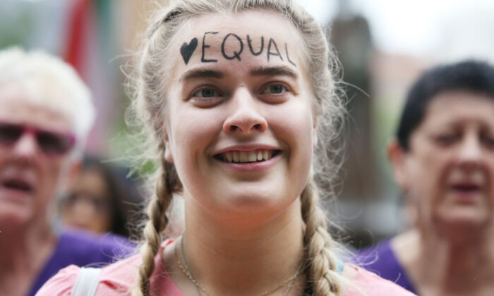 A woman smiles with the word "equal" written on her forehead as she gathers in Hyde Park during the International Women's Day march in Sydney, Australia, on March 7, 2020. (Lisa Maree Williams/Getty Images)
