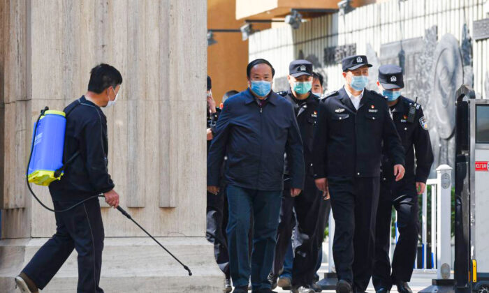 Police and officials emerge from a high school in Beijing on April 27, 2020. (Greg Baker/AFP via Getty Images)