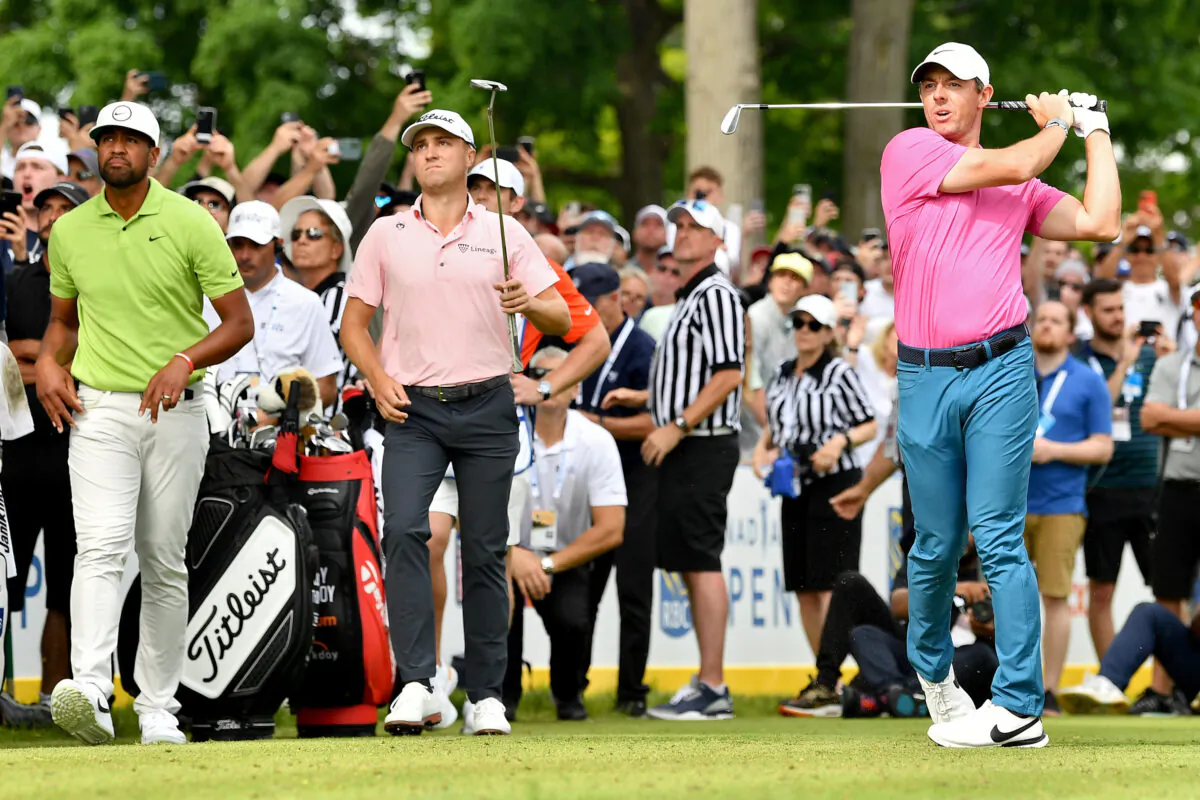 Rory McIlroy of Northern Ireland plays his shot from the 16th tee as Tony Finau of the United States and Justin Thomas of the United States look on during the final round of the RBC Canadian Open at St. George's Golf and Country Club, in Etobicoke, Ontario, on June 12, 2022. (Minas Panagiotakis/Getty Images)