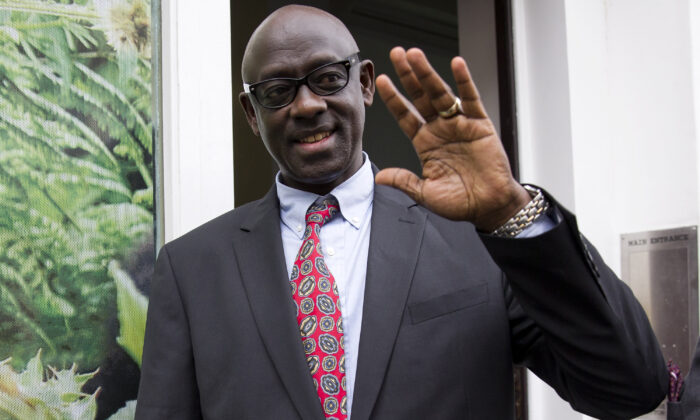 Rwanda Justice Minister Johnston Busingye waves as he leaves the Rwanda High Commission in London after a court in Britain dropped an extradition case against Rwanda's Intelligence chief, General Karenzi Karake on Aug. 10, 2015. (Justin Tallis/AFP via Getty Images)