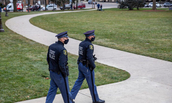 Police patrol outside the Michigan State Capitol as pro-Trump demonstrators protest nearby in Lansing, Mich., on Dec. 14, 2020. (Elaine Cromie/Getty Images)