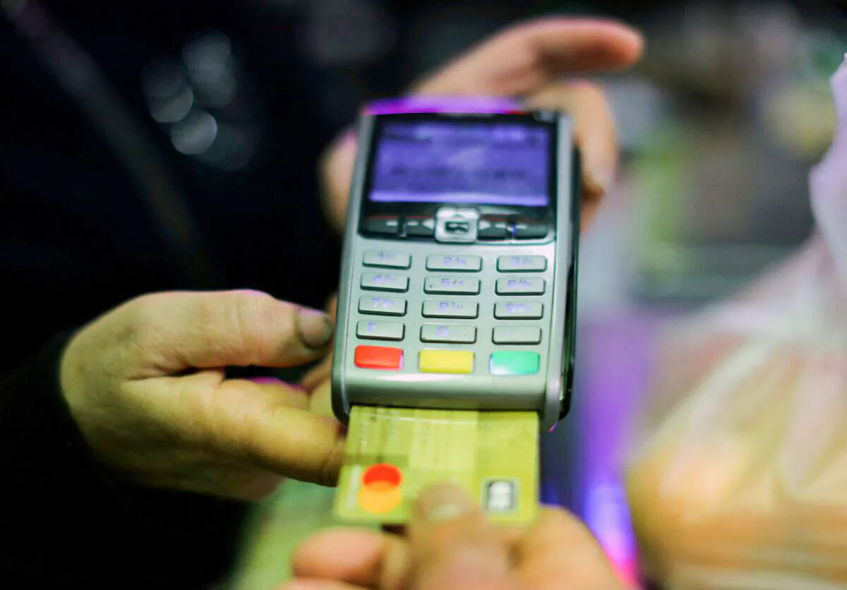 A shopper uses a credit card to pay for goods in a grocery in Nice, France, on April 3, 2019. (Eric Gaillard/Reuters)