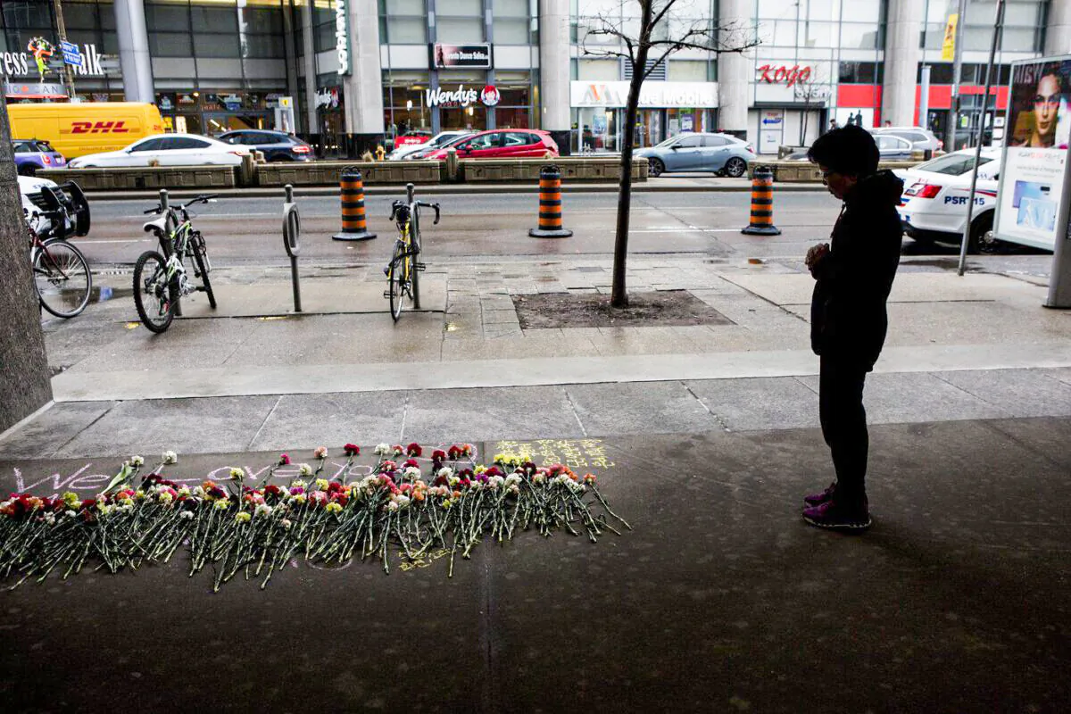 A woman stops to pay her respect at a makeshift memorial to one of the victims of the Toronto van attack being remembered on April 23, 2019. (The Canadian Press/Chris Young)
