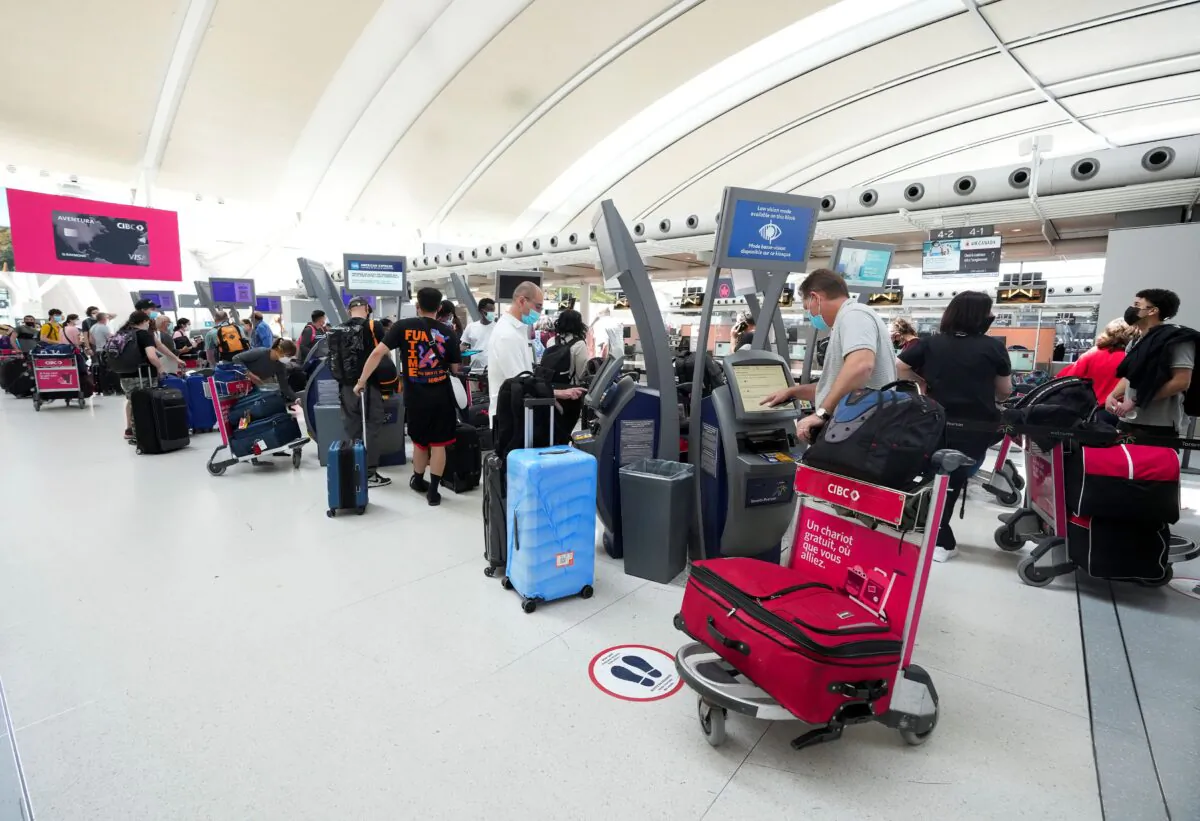 People wait in line to check in at Pearson International Airport in Toronto on May 12, 2022. (The Canadian Press/Nathan Denette)