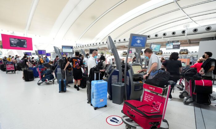 People wait in line to check in at Pearson International Airport in Toronto on May 12, 2022. (The Canadian Press/Nathan Denette)