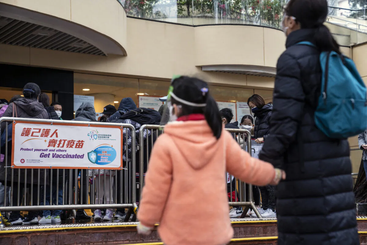 Residents queue outside a community vaccination center administering the Sinovac Biotech Ltd. Covid-19 vaccine to children and elderly ahead of its opening hours in Hong Kong, on Feb. 23, 2022. (Chan Long Hei/Bloomberg)