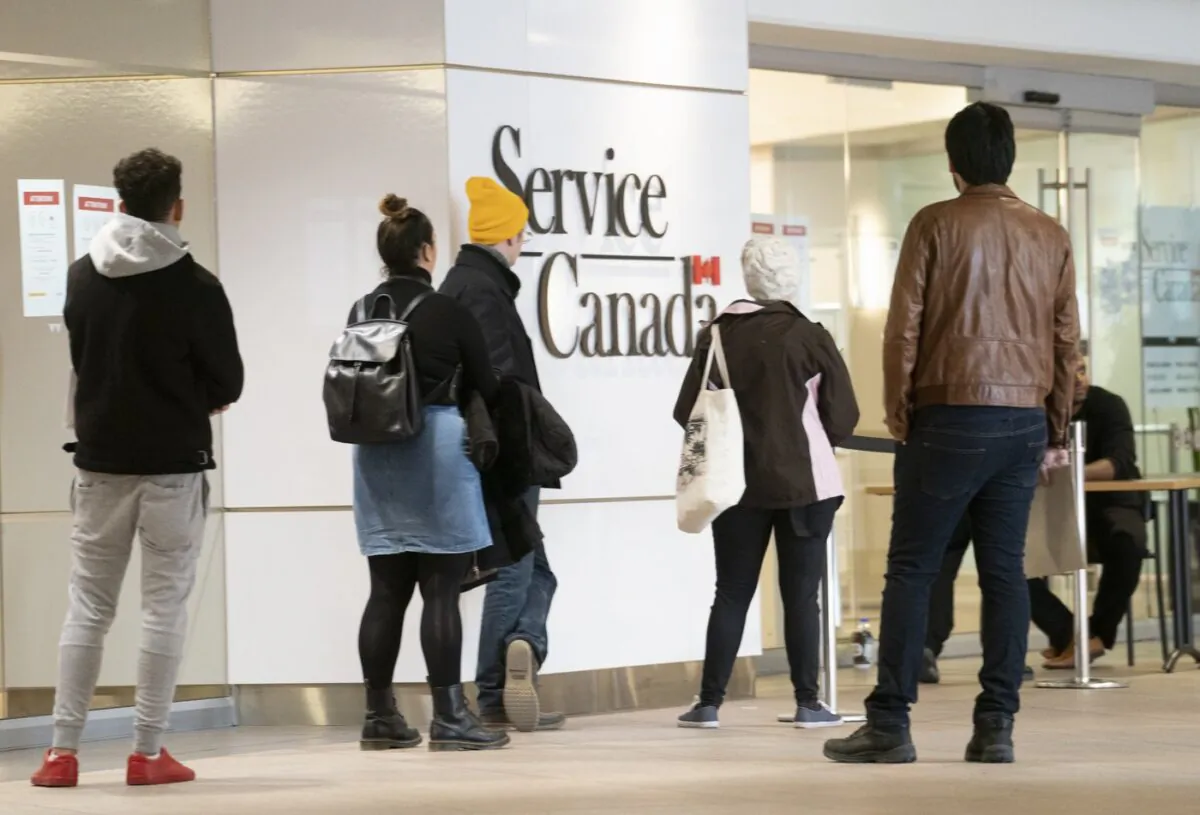 People line up at a Service Canada office in Montreal on March 19, 2020. (The Canadian Press/Paul Chiasson)