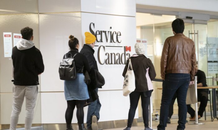 People line up at a Service Canada office in Montreal on March 19, 2020. (The Canadian Press/Paul Chiasson)