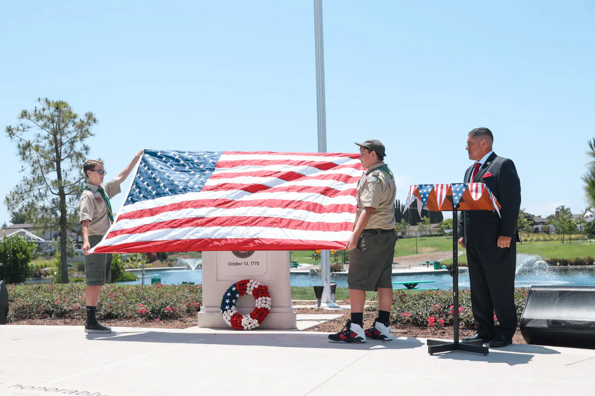 Boy Scout Troop 628 and Lake Forest Mayor Robert Pequeño present the American flag at a celebration for Flag Day at Veterans Park in Lake Forest, Calif., on June 14, 2022. (Julianne Foster/The Epoch Times)