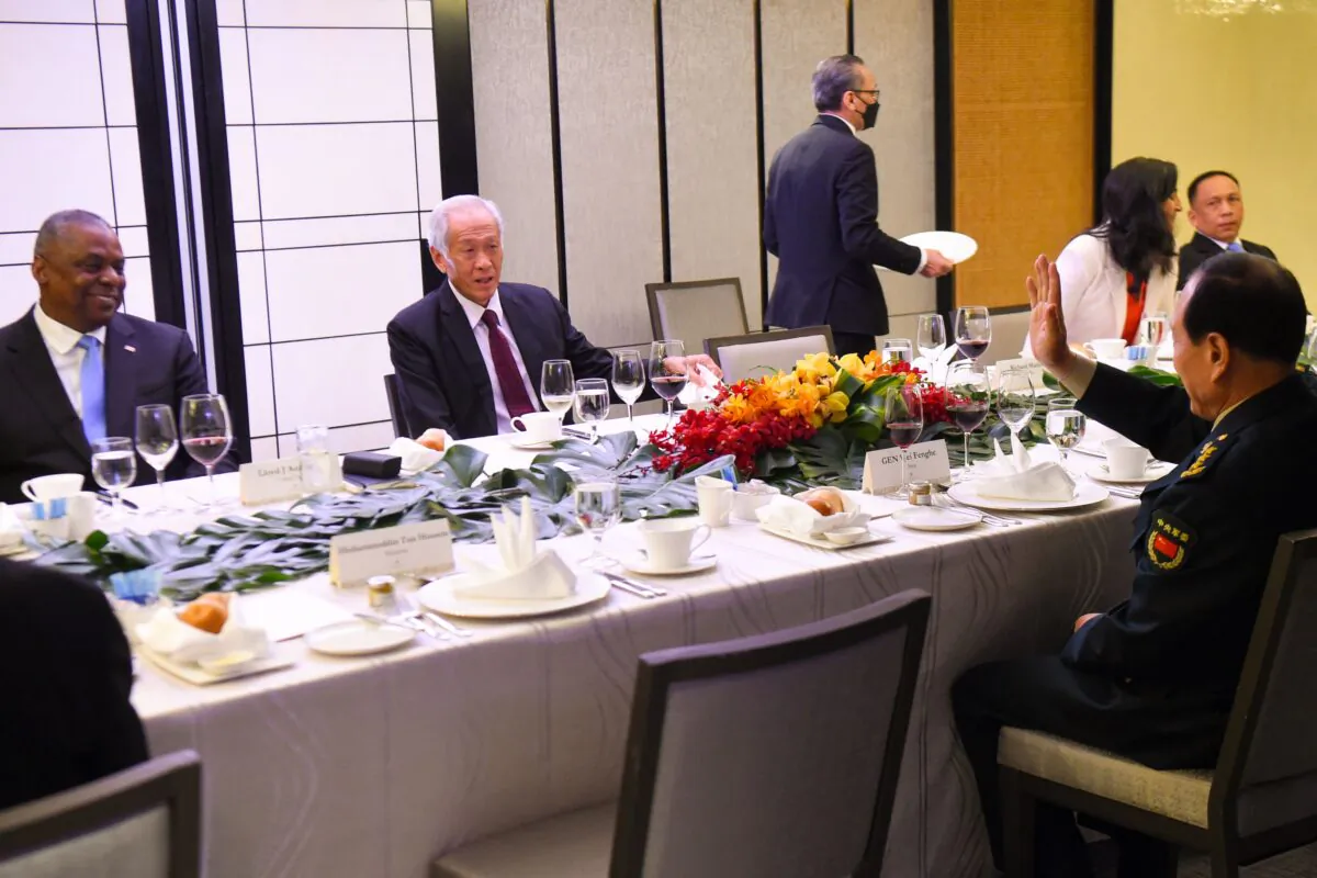 China's Defense Minister Wei Fenghe (R) greets U.S. Defense Secretary Lloyd Austin (L) as he sits across from Singapore's Defense Minister Ng Eng Hen during the ministerial roundtable luncheon at the Shangri-La Dialogue summit in Singapore on June 11, 2022. (Roslan Rahman/AFP via Getty Images)
