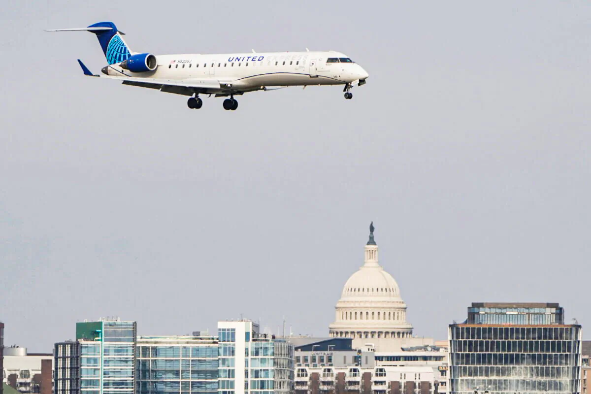 A United Airlines aircraft flies past the U.S. Capitol before landing at Reagan National Airport in Arlington, Va. on Jan. 24, 2022. (Joshua Roberts/Reuters)