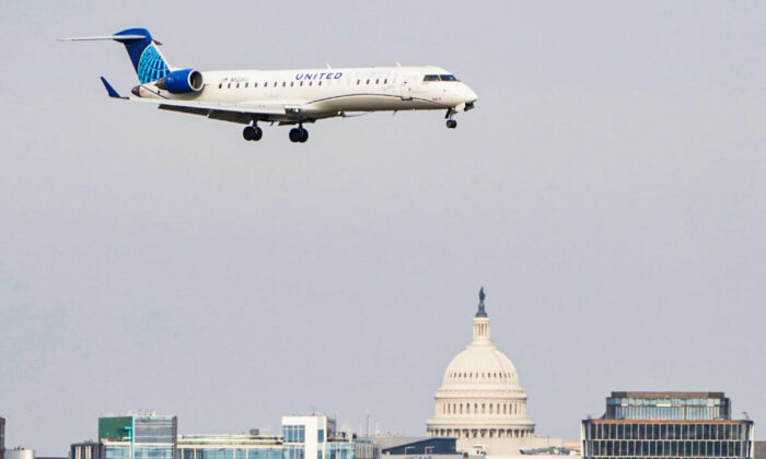 A United Airlines aircraft flies past the U.S. Capitol before landing at Reagan National Airport in Arlington, Va. on Jan. 24, 2022. (Joshua Roberts/Reuters)