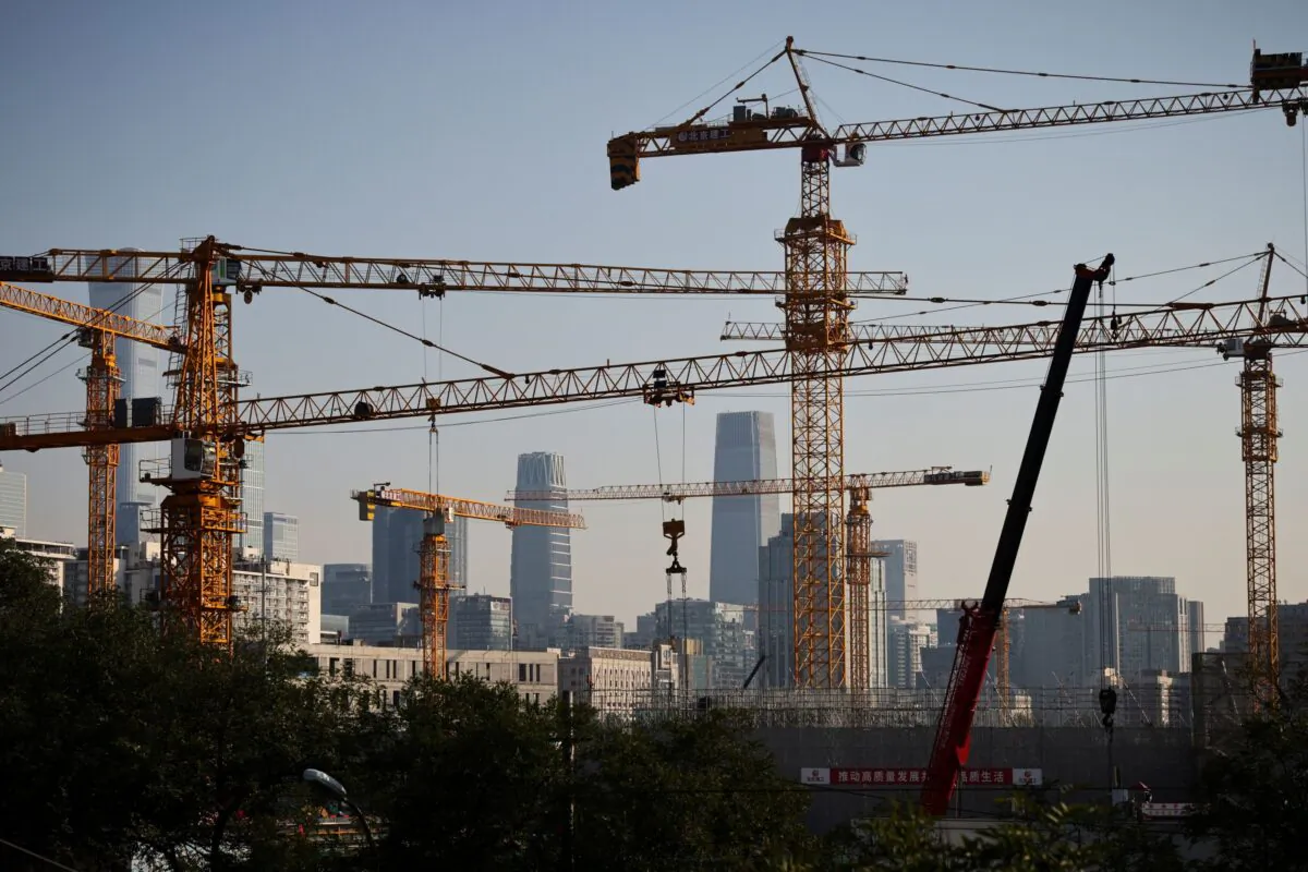 A view shows cranes in front of the skyline of the Central Business District in Beijing on Oct. 18, 2021. (Thomas Peter/Reuters)