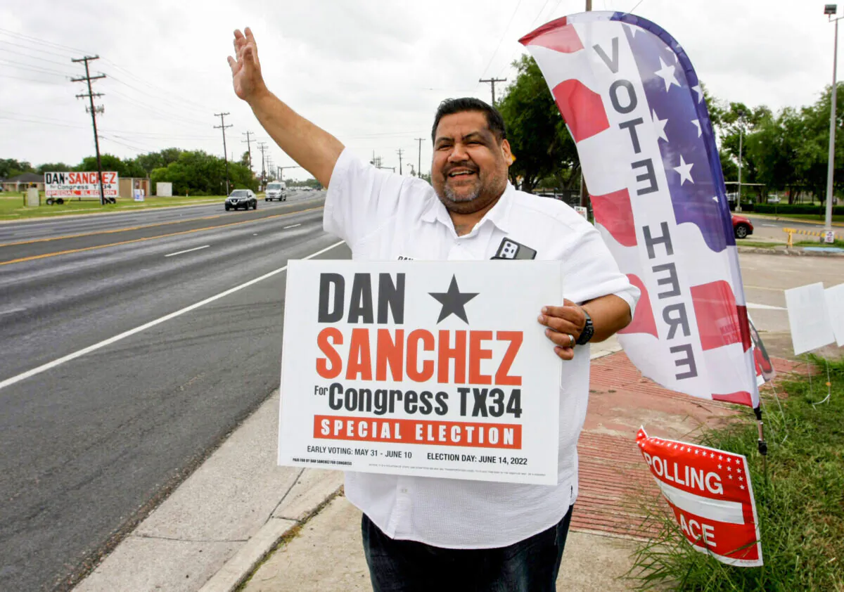 Democratic candidate Dan Sanchez waves to drivers outside a polling place in Brownsville, Texas, on June 14, 2022, as voters decide who represents them in the 34th Congressional District. (Bobby Sanchez/The Epoch Times)