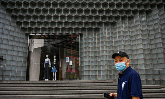 A man walks past a closed shop during a COVID-19 lockdown in the Jing'an district of Shanghai on May 30, 2022. (Hector Retamal/AFP via Getty Images)