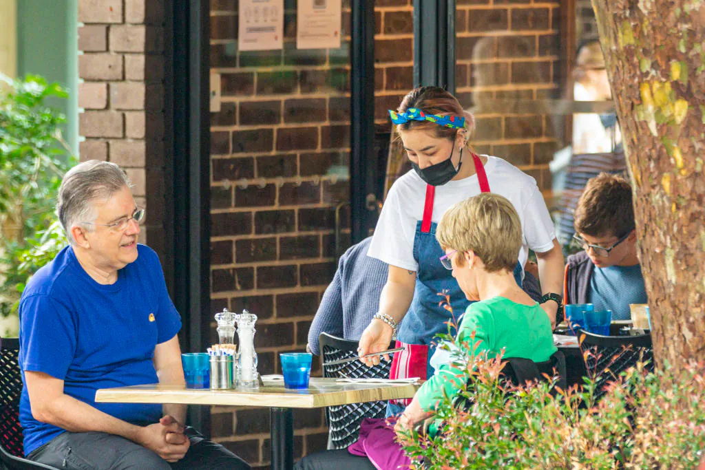 A waitress is seen delivering cutlery at a cafe in Mosman, Sydney, Australia, on Jan. 3, 2021. (Jenny Evans/Getty Images)