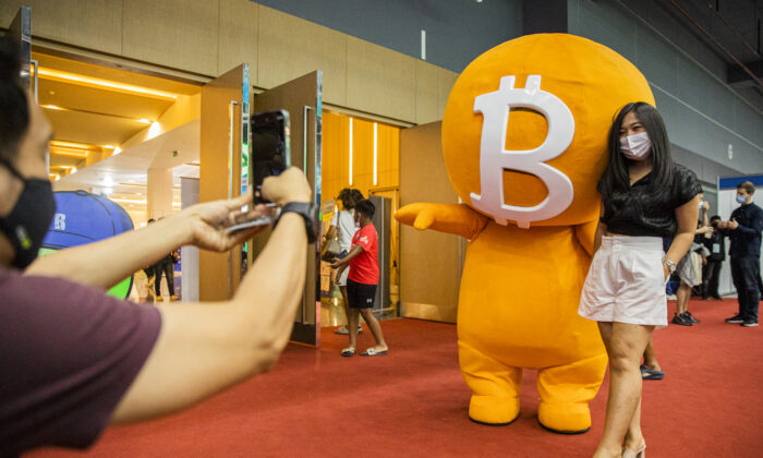 A woman poses with a Bitcoin mascot during the Thailand Crypto Expo 2022 in Bangkok on May 14, 2022. The expo was held amid a global market crash. (Lauren DeCicca/Getty Images)