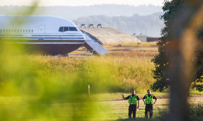 Police officers stand near a plane reported by British media to be first to transport illegal immigrants to Rwanda at MoD Boscombe Down base in Wiltshire, Britain, on June 14, 2022. (Hannah McKay /Reuters)