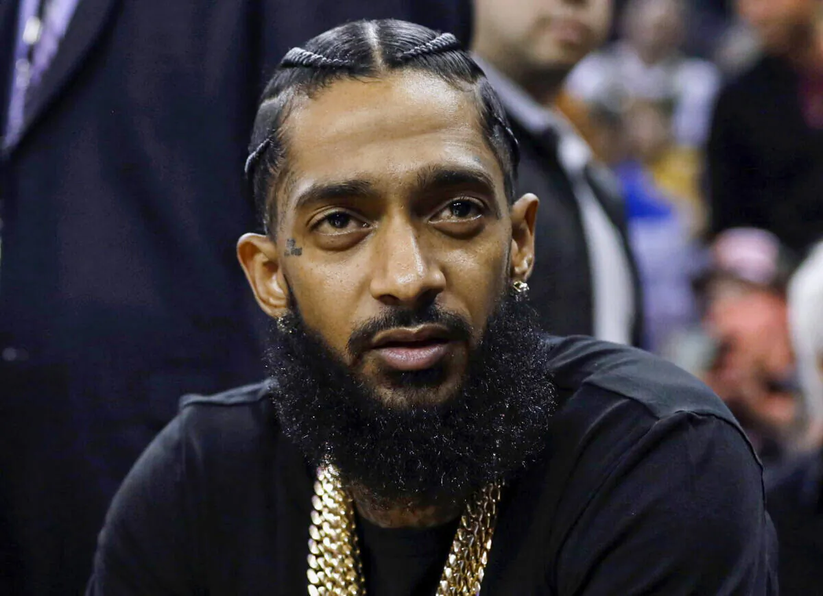 Rapper Nipsey Hussle attends an NBA basketball game between the Golden State Warriors and the Milwaukee Bucks in Oakland, Calif., on March 29, 2018. (Marcio Jose Sanchez/AP Photo)