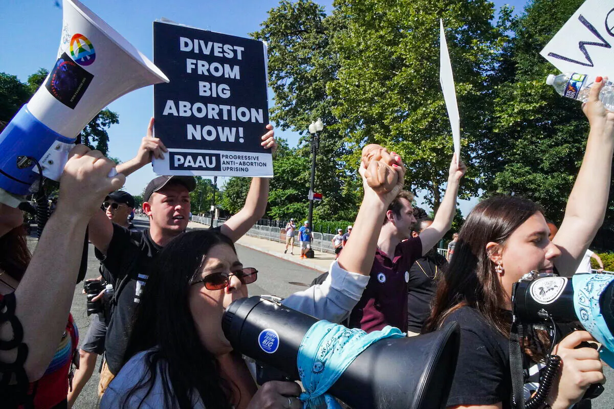 Left-wing pro-life protesters with Progressive Anti-Abortion Uprising protest outside the U.S. Supreme Court on June 15, 2022.(Jackson Elliott/The Epoch Times)