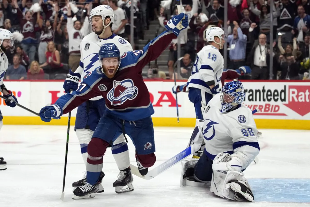 Colorado Avalanche left wing J.T. Compher (L) celebrates next to Tampa Bay Lightning goaltender Andrei Vasilevskiy (R) after an overtime goal by Andre Burakovsky in Game 1 of the NHL hockey Stanley Cup Final in Denver on June 15, 2022. (John Locher/AP Photo)