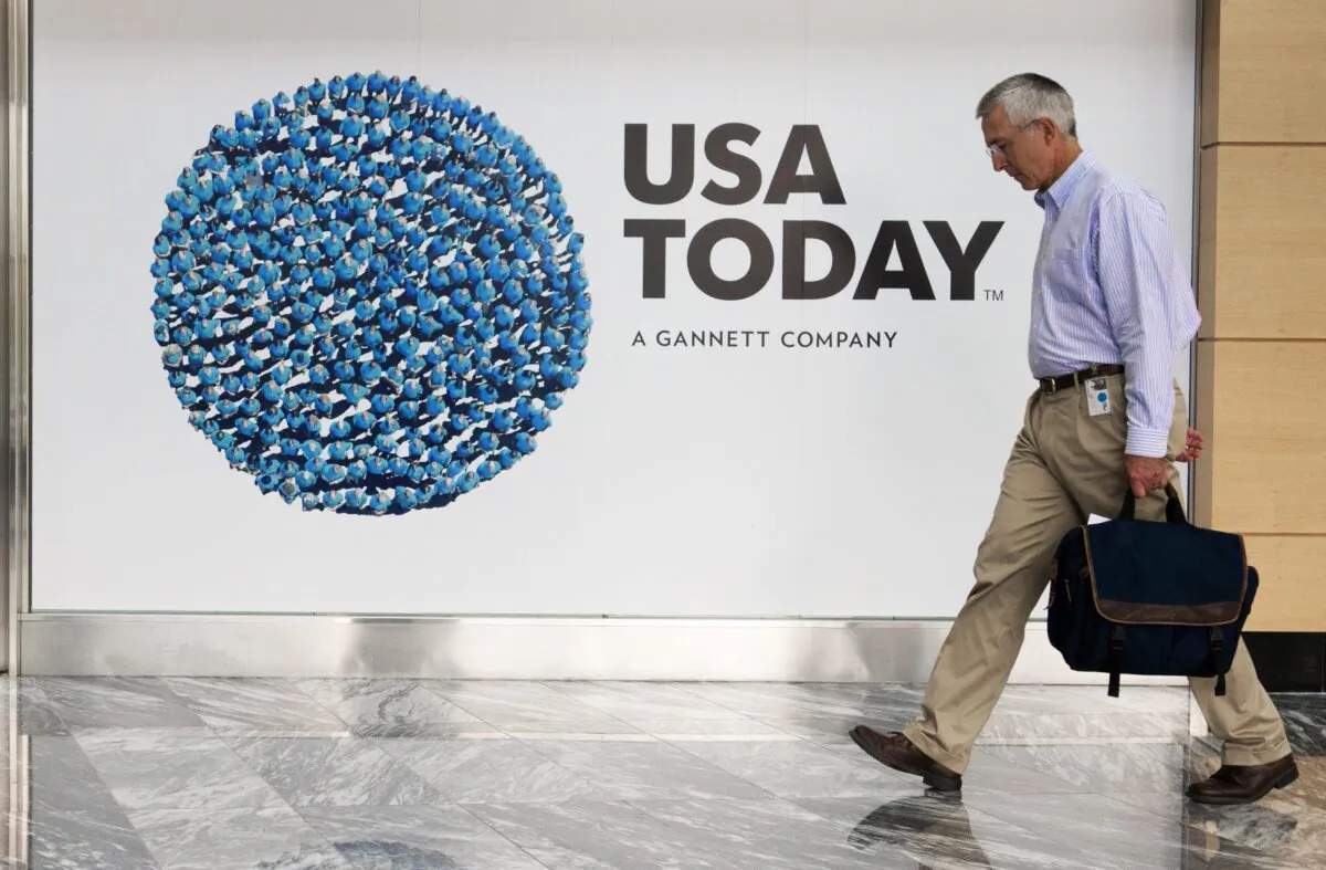 An unidentified man walks through the lobby of the Gannett-USA Today headquarters building in McLean, Va., on Aug. 20, 2013. (Paul J. Richards/AFP via Getty Images)