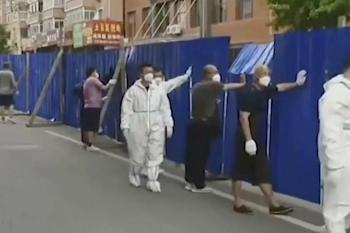 Workers set up fences around a community under lockdown in Dandong city, in northeastern China's Liaoning province, on June 13, 2022. (DOUYIN@91244624 via AP)