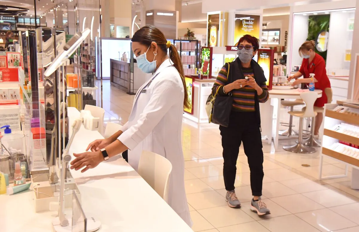 A woman walks past an employee at a department store in Melbourne, Australia, on Oct. 28, 2020. (William West/AFP via Getty Images)