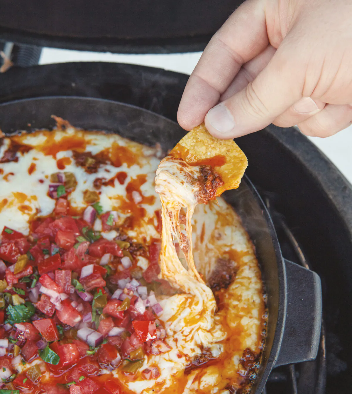 Snack on chips and queso fundido, cooked in cast iron skillets on the grill, while you grill the rest of your feast. (Ken Goodman)