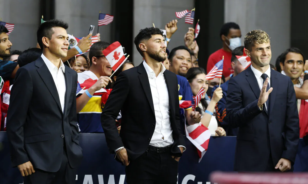 International soccer players Hirving "Chucky" Lozano (L), Jonathan Osorio (C) and Christian Pulisic wait along 6th Ave. for FIFA's announcement of the names of the host cities for the 2026 World Cup soccer tournament in New York on June 16, 2022. (Noah K. Murray/AP Photo)