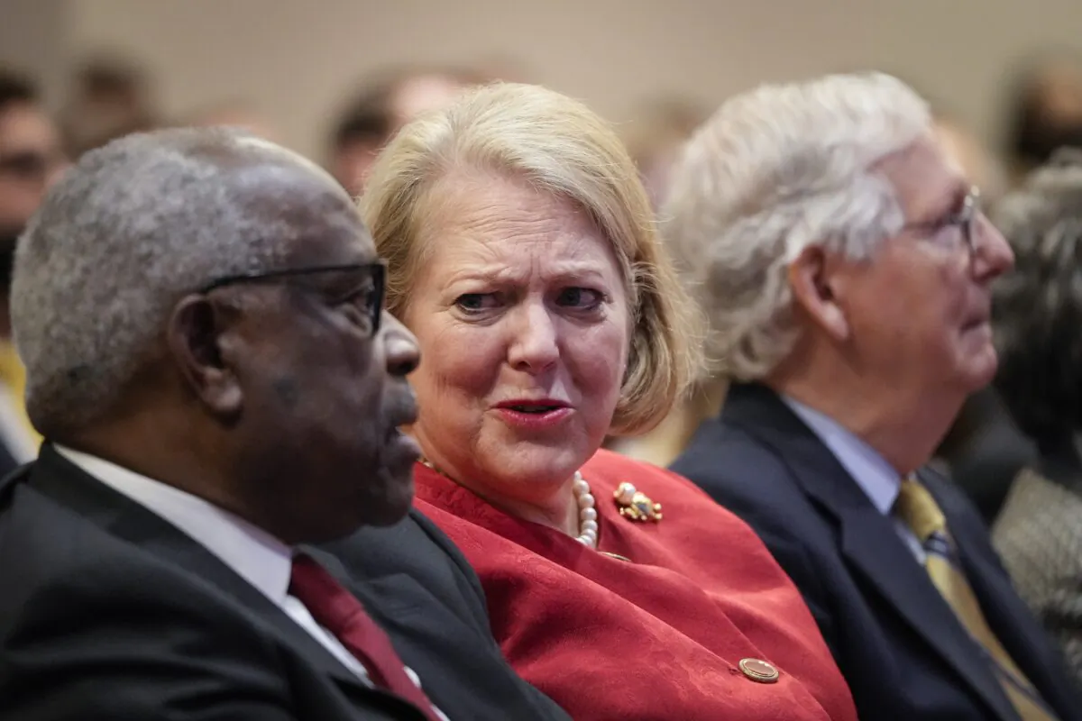 Ginni Thomas, center, speaks to Supreme Court Justice Clarence Thomas during an event in Washington on Oct. 21, 2021. (Drew Angerer/Getty Images)