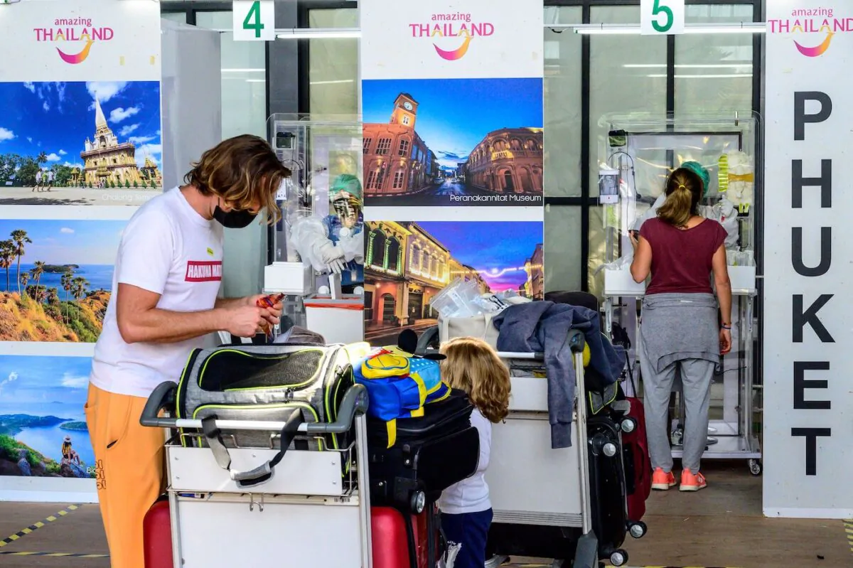 Arriving passengers wait for a PCR swab test to be taken at the arrival area at Phuket International Airport as Thailand welcomes the first group of tourists fully vaccinated against the COVID-19 coronavirus without quarantine in Phuket on Nov. 1, 2021. (Mladen Antonov/AFP via Getty Images)